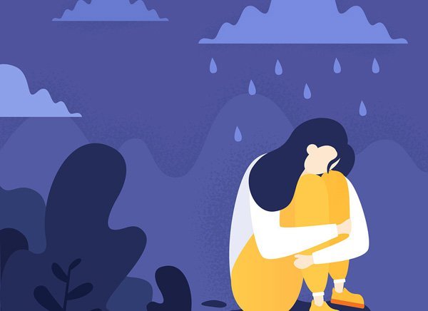 A woman hugs her knees in the rain, symbolizing the sadness and grief that condolence messages aim to comfort.