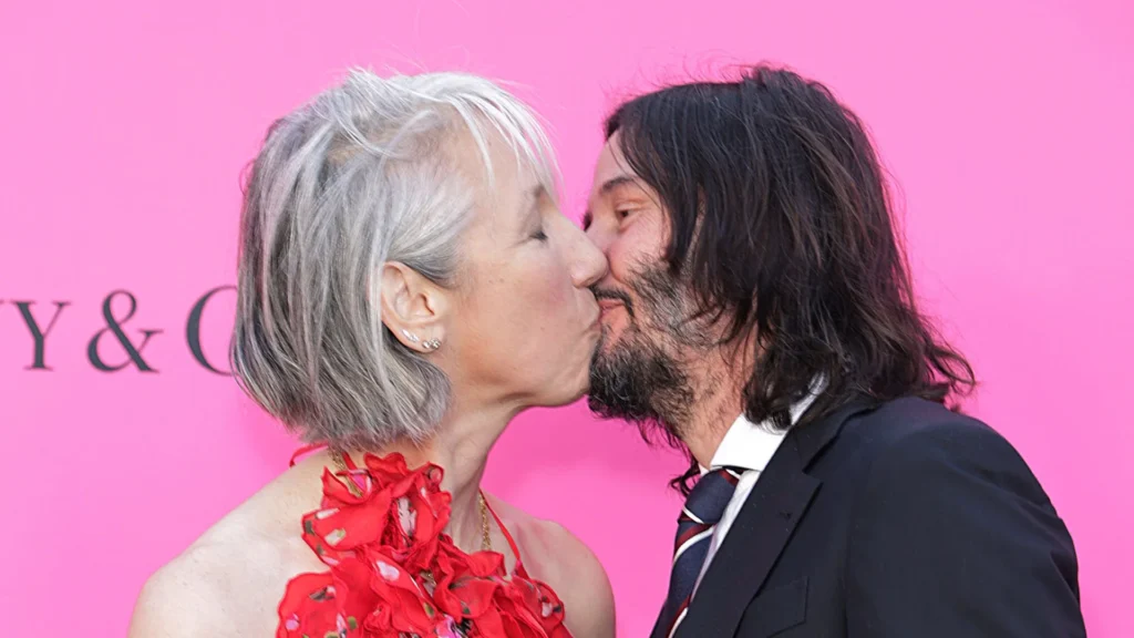 Keanu Reeves and Alexandra Grant sharing a kiss on the red carpet at the MOCA Gala.