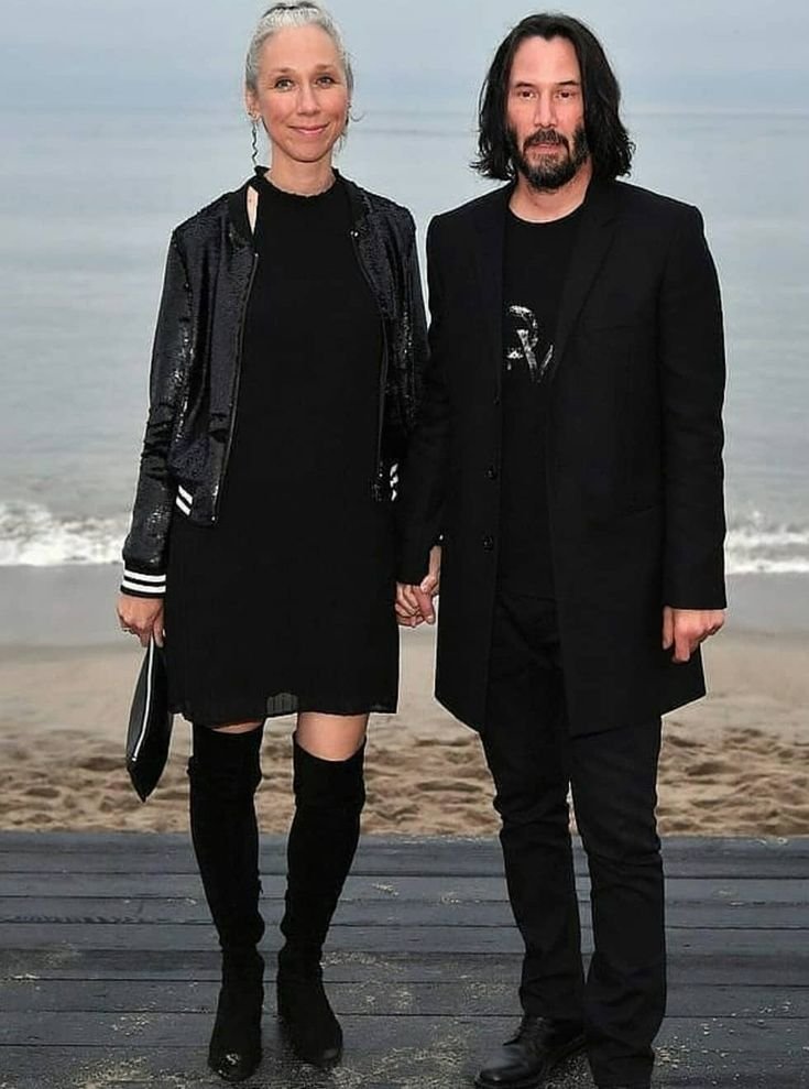  Keanu Reeves and Alexandra Grant holding hands at the Saint Laurent fashion show.