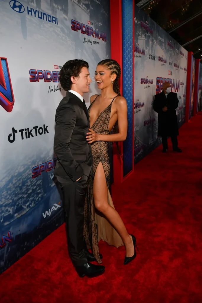 Tom Holland looking at Zendaya as she arrives at the Los Angeles premiere of Spider-Man: No Way Home.