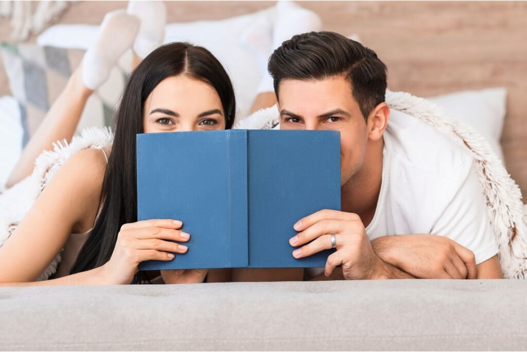 A couple holding a book containing valentine's day poems.