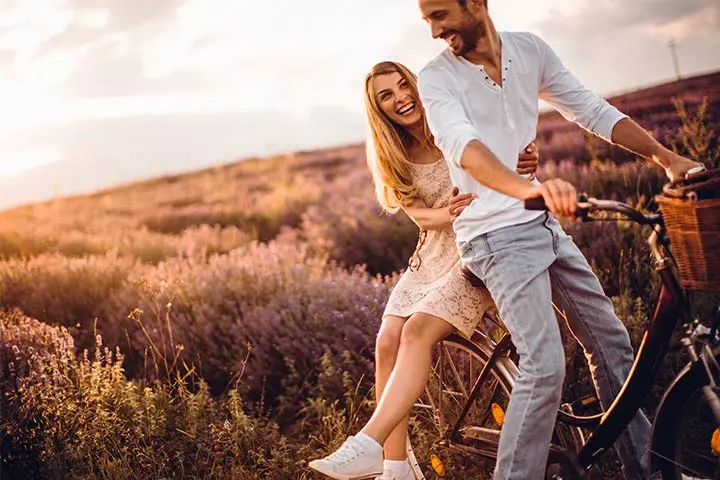 Good morning message: A happy couple laughing while cycling.